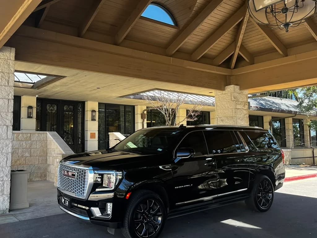 A Leo Limos GMC Denali SUV waiting under a luxury resort porte-cochère